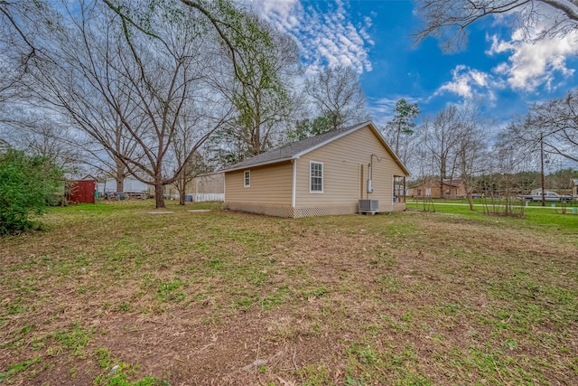 view of property exterior featuring a lawn, central AC, and fence