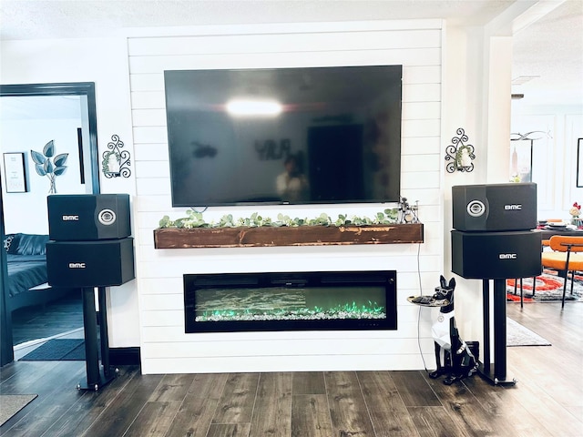 details featuring a fireplace, a textured ceiling, and wood finished floors