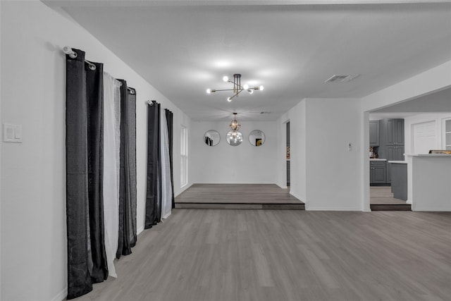 interior space featuring an inviting chandelier and light hardwood / wood-style flooring