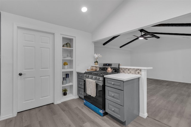 kitchen with gray cabinets, vaulted ceiling with beams, stainless steel gas range, and light hardwood / wood-style floors