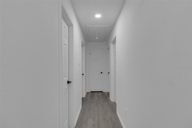 hallway with light hardwood / wood-style floors