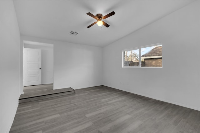 unfurnished room with ceiling fan, vaulted ceiling, and light wood-type flooring