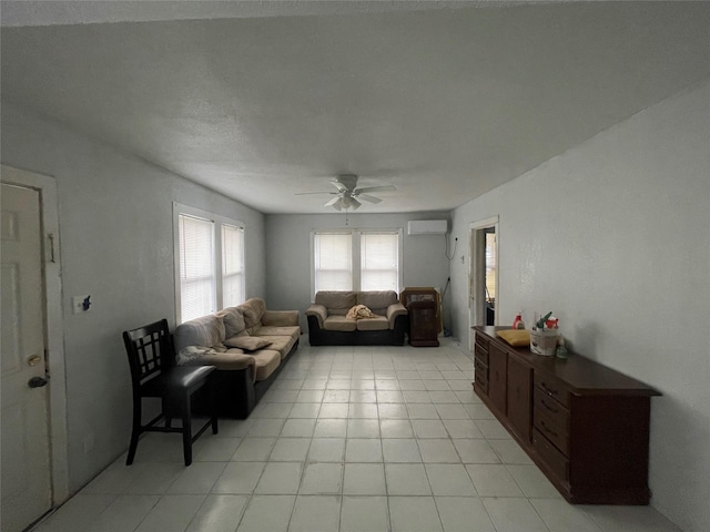 living room with ceiling fan, light tile patterned floors, and an AC wall unit