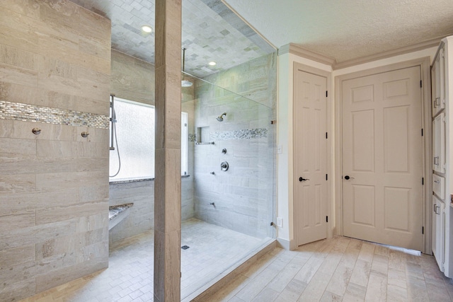 bathroom with wood-type flooring and a tile shower