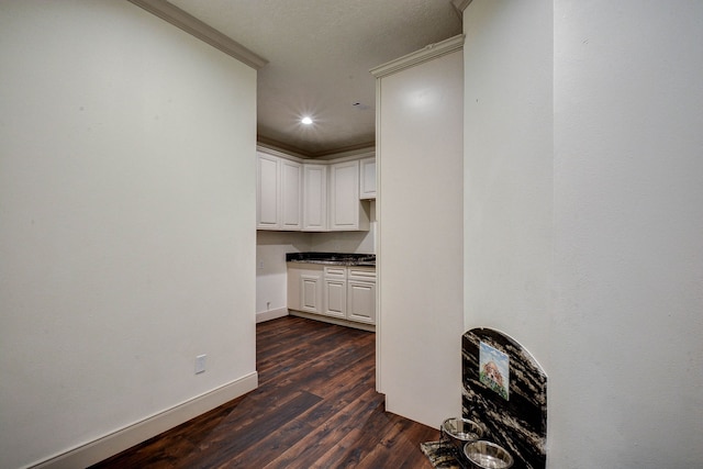 interior space featuring crown molding and dark wood-type flooring