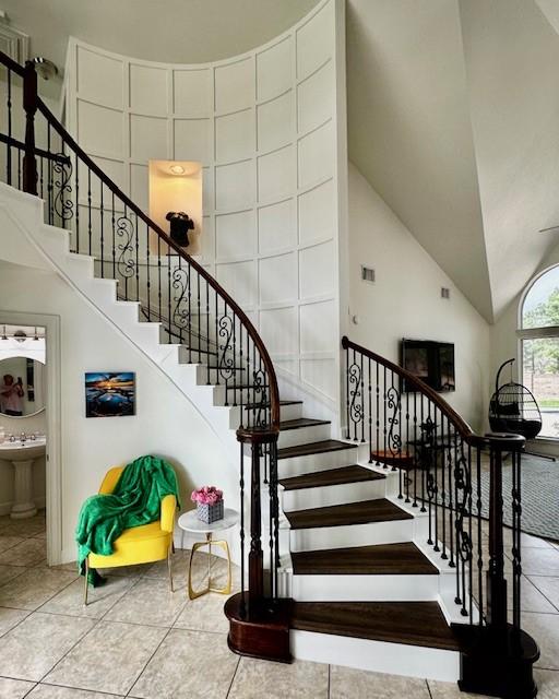 staircase featuring tile patterned flooring and lofted ceiling