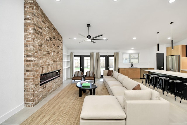 living room featuring french doors, lofted ceiling, sink, and a brick fireplace