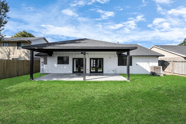 rear view of property featuring a patio, a yard, cooling unit, and french doors