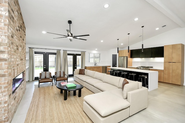 living room featuring french doors, a fireplace, sink, and lofted ceiling with beams