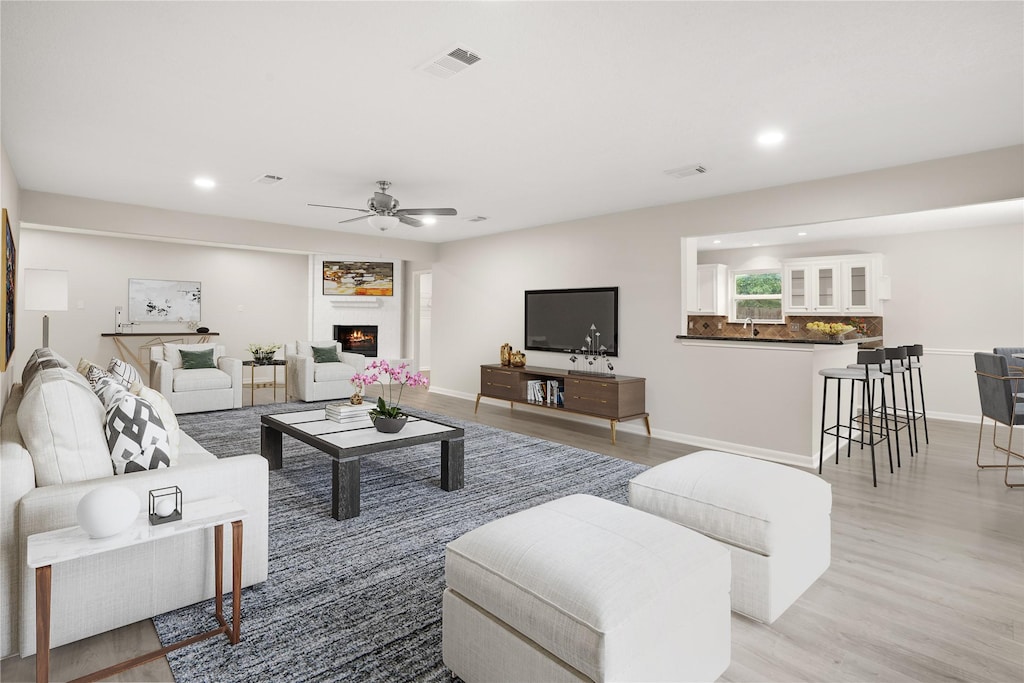 living room with ceiling fan and light wood-type flooring