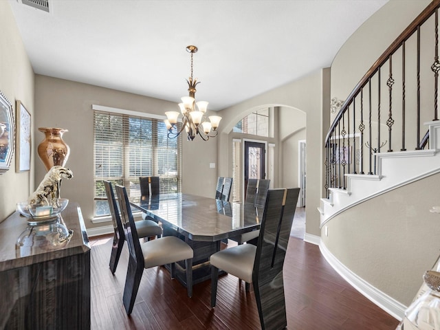 dining area featuring hardwood / wood-style flooring, an inviting chandelier, and a wealth of natural light