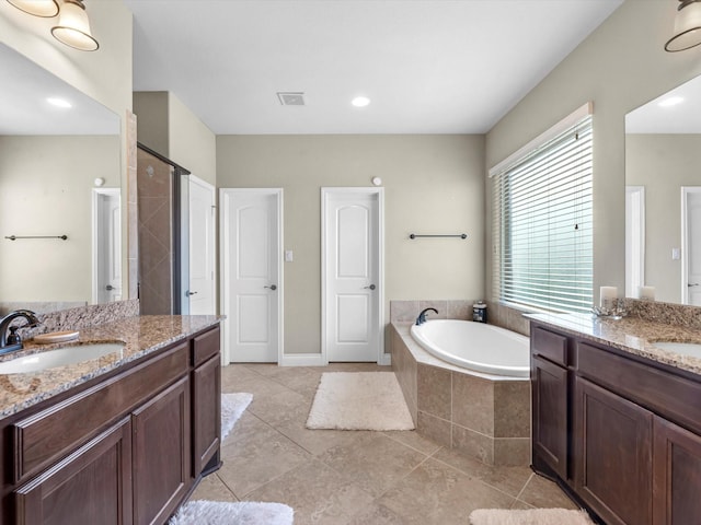 bathroom with tile patterned flooring, vanity, and shower with separate bathtub