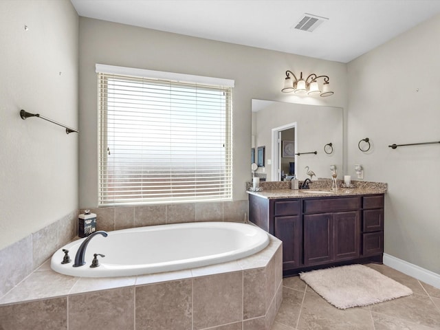 bathroom with vanity, a relaxing tiled tub, and tile patterned floors