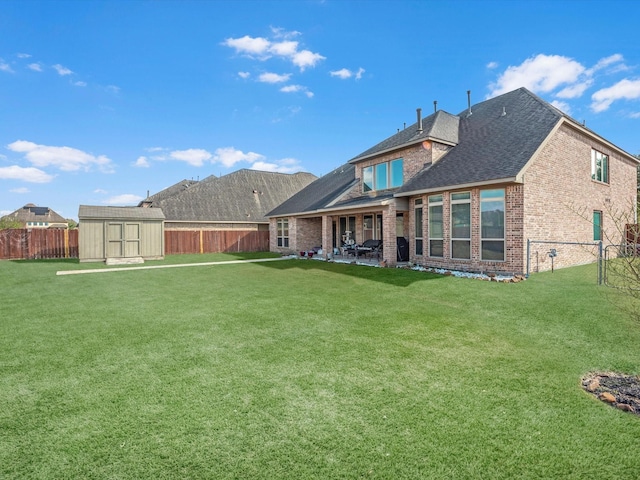 rear view of house with a yard, a patio area, and a shed