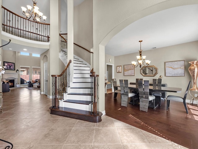 tiled entrance foyer featuring a towering ceiling and a chandelier