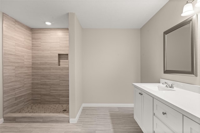 bathroom with vanity and a tile shower