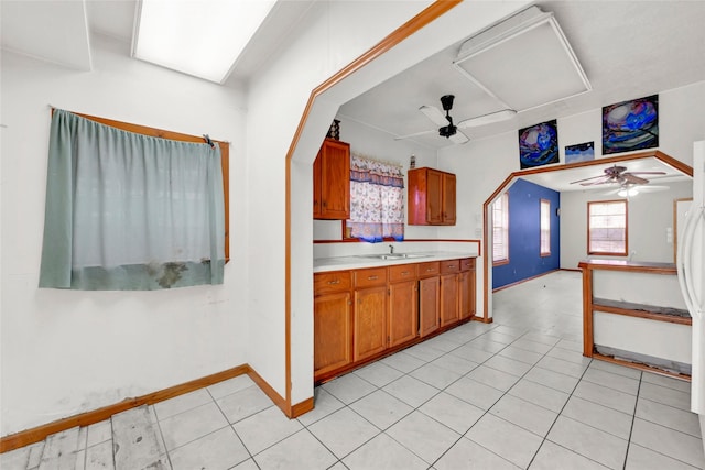 kitchen with light tile patterned flooring, ceiling fan, and sink