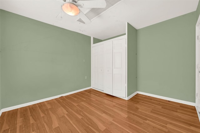 unfurnished bedroom featuring hardwood / wood-style flooring, ceiling fan, and a closet