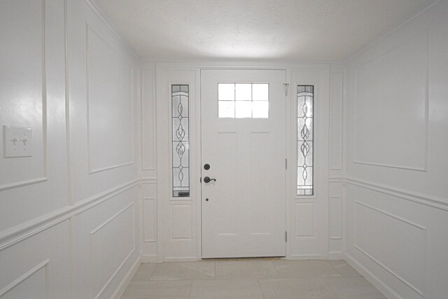 tiled foyer entrance featuring a textured ceiling