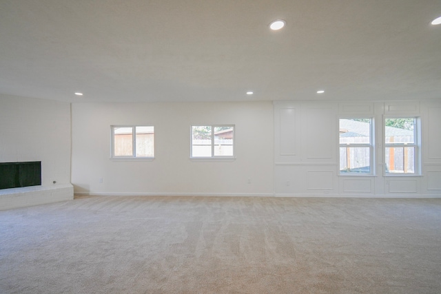 empty room featuring light colored carpet and a fireplace