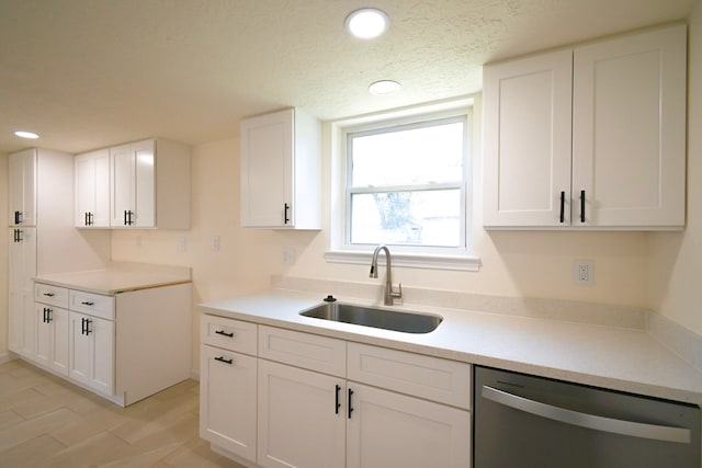 kitchen with white cabinetry, sink, stainless steel dishwasher, and a textured ceiling