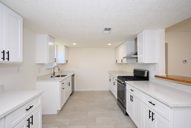 kitchen with appliances with stainless steel finishes, sink, wall chimney range hood, and white cabinets