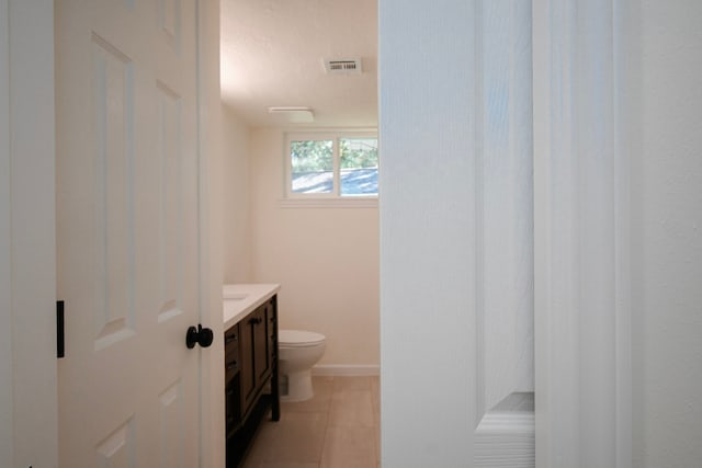 bathroom featuring tile patterned flooring, vanity, and toilet