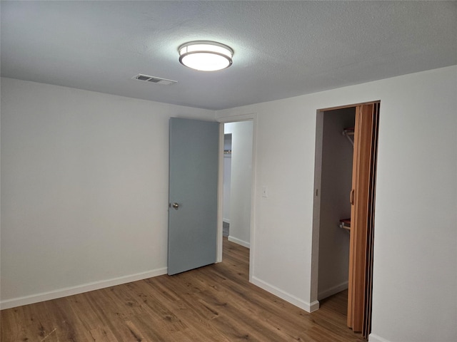 unfurnished bedroom with hardwood / wood-style flooring and a textured ceiling