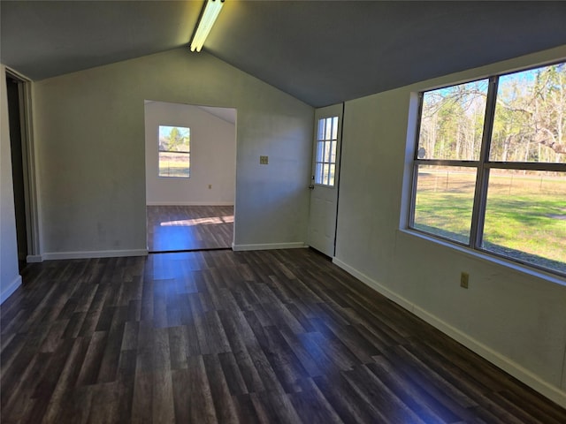 unfurnished room with plenty of natural light, vaulted ceiling with beams, and dark hardwood / wood-style flooring