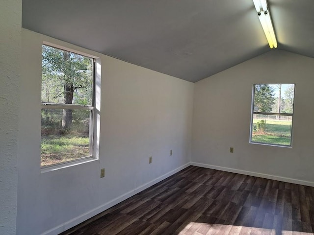 empty room featuring dark wood-type flooring, plenty of natural light, and vaulted ceiling with beams