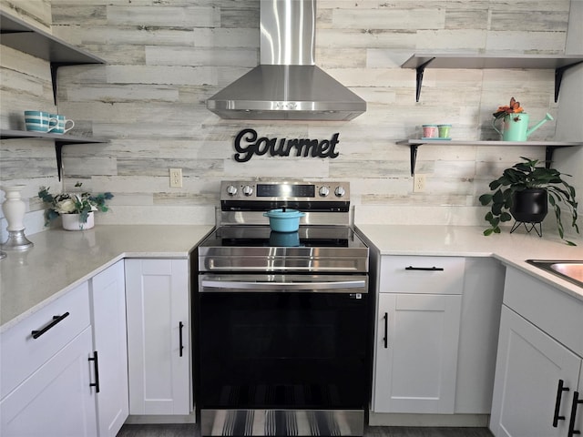 kitchen with white cabinets, wall chimney exhaust hood, open shelves, and electric stove