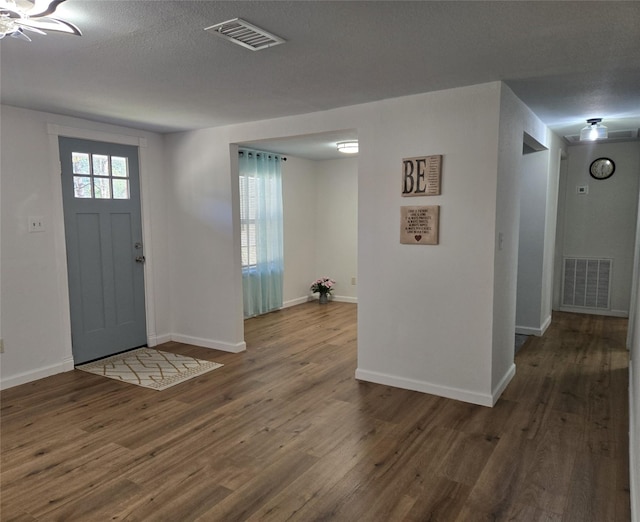 foyer with dark wood-type flooring and a textured ceiling