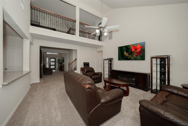 carpeted living room with high vaulted ceiling and ceiling fan