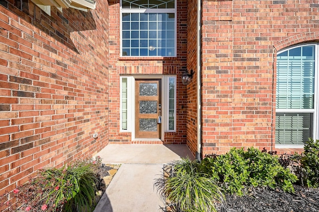 doorway to property featuring brick siding