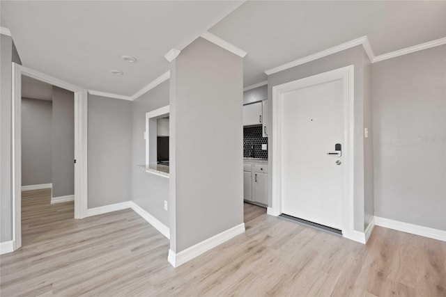 spare room featuring crown molding and light hardwood / wood-style flooring