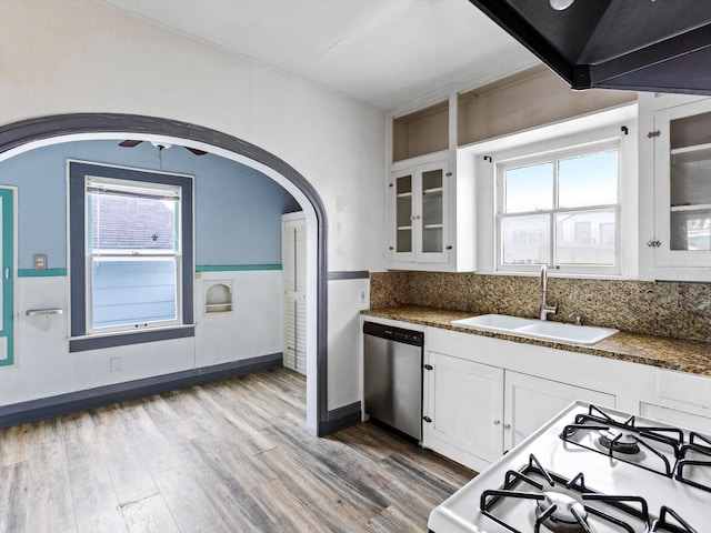 kitchen featuring white range with gas cooktop, white cabinets, glass insert cabinets, stainless steel dishwasher, and a sink