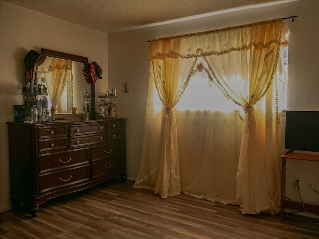 bedroom with dark hardwood / wood-style flooring and a textured ceiling