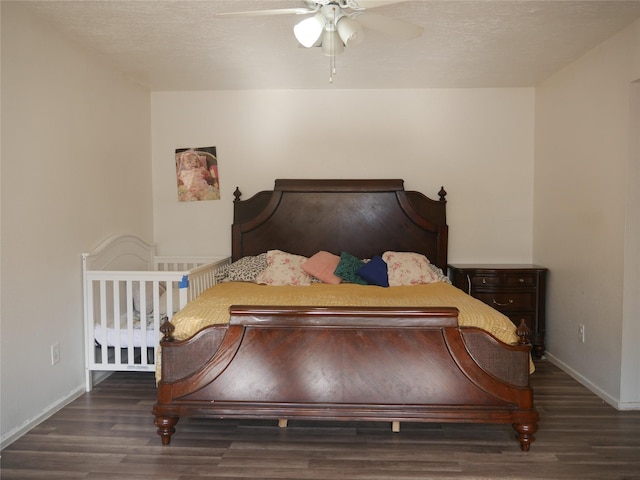 bedroom with ceiling fan, dark hardwood / wood-style flooring, and a textured ceiling