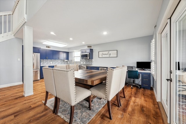 dining space featuring baseboards, visible vents, wood finished floors, and recessed lighting