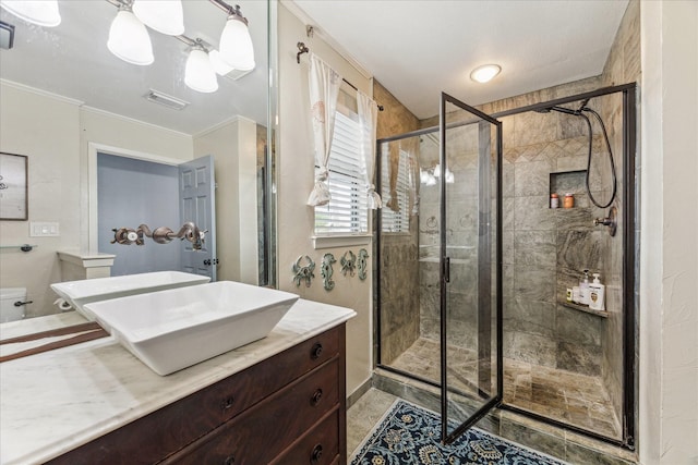 full bathroom featuring visible vents, a stall shower, vanity, and crown molding