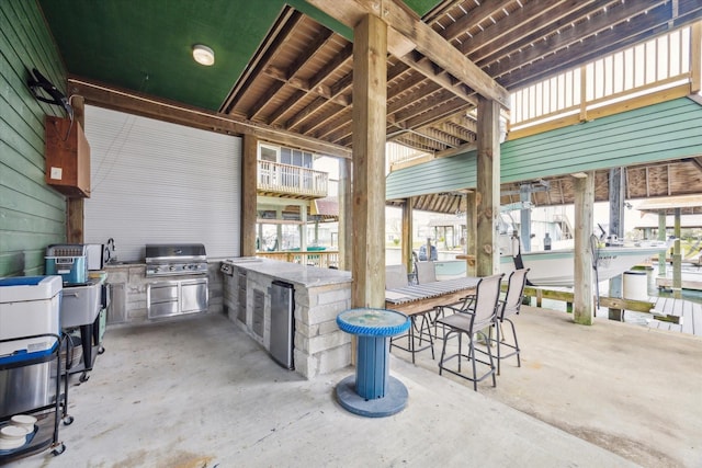 view of patio / terrace featuring a sink, an outdoor kitchen, a grill, and outdoor wet bar