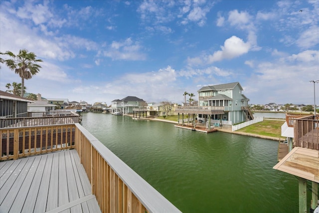 view of dock featuring a residential view and a deck with water view