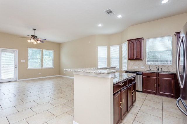 kitchen with dishwasher, sink, decorative backsplash, a center island, and light tile patterned floors