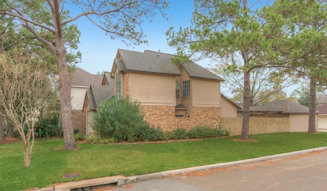 view of home's exterior with a shingled roof, a lawn, and brick siding