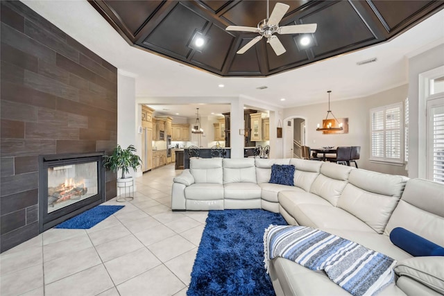 tiled living room featuring ceiling fan, a multi sided fireplace, and ornamental molding