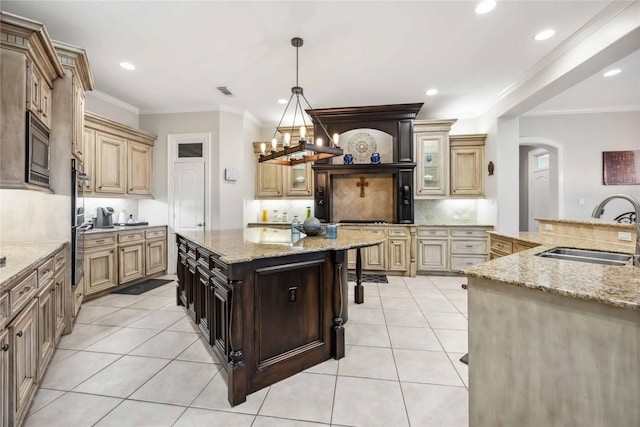 kitchen featuring appliances with stainless steel finishes, sink, light tile patterned floors, light stone counters, and dark brown cabinetry