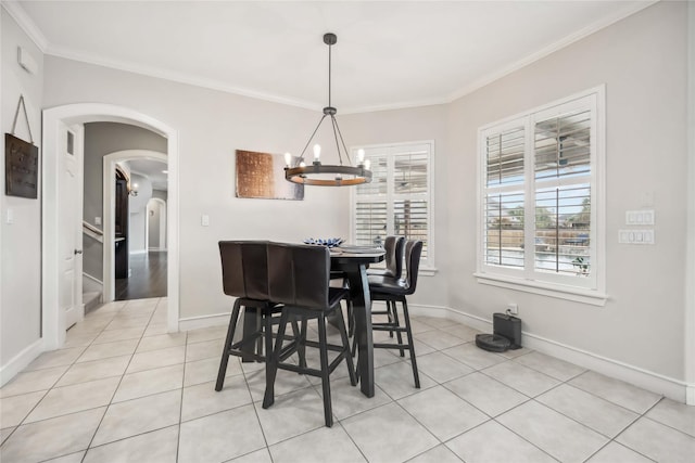 tiled dining area featuring a notable chandelier and crown molding