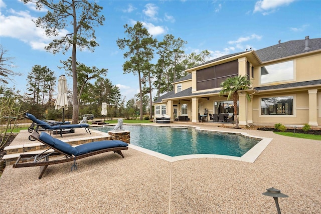 view of swimming pool with a sunroom and a patio