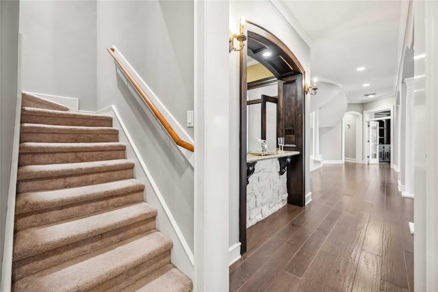 stairway featuring wood-type flooring and ornamental molding