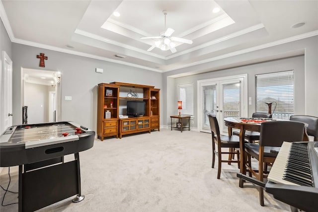 rec room featuring ornamental molding, light colored carpet, ceiling fan, and a tray ceiling